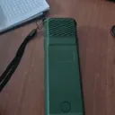 Customer photo of the MoskiCell unit with its lanyard lying flat on a timber desk beside a laptop