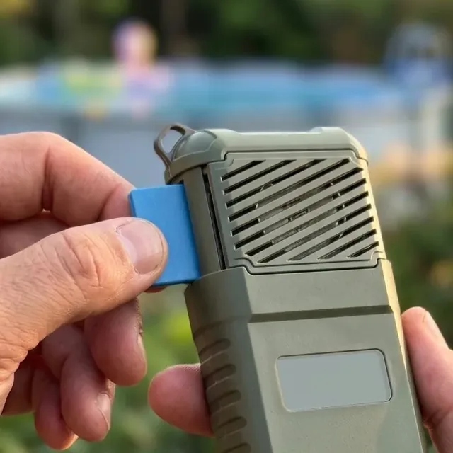 A hand sliding a blue repellent tablet into the slot beneath the vent grille of the MoskiCell unit